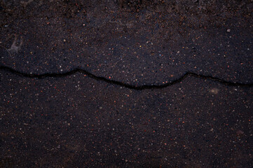 asphalt texture. cracked road. crack in the ground. the asphalt is old. Black background