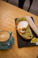 Breakfast of coffee and avocado and egg toast
