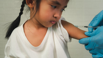 Doctor vaccinating cute little girl in hospital,Concept fight against virus covid-19 corona virus