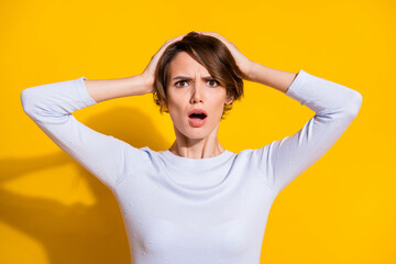 Fototapeta premium Photo portrait of unhappy woman in panic touching head isolated on bright yellow colored background