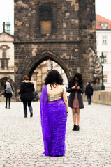 Naklejka premium Woman in purple dress standing on bridge in old town
