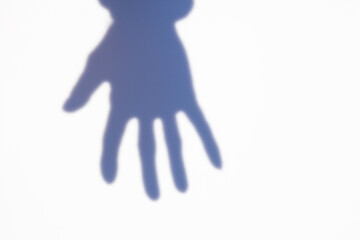 Blurry shadow, Shadowy figure, human body, male hand behind glass. White wall background.
