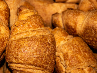 Delicious crispy yellow croissants with filling lie in a pile