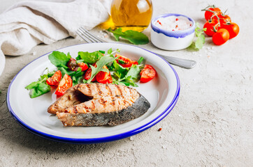 Grilled Pink salmon steak and salad on concrete background. Healthy food concept.