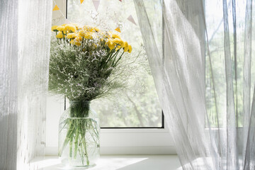 View of a bouquet of yellow chrysanthemums in a vase on the window. Concept background, flowers, holiday.