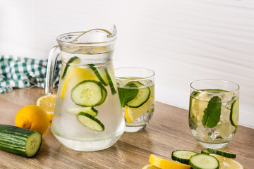 Sassy water or water with cucumber and lemon on wooden table