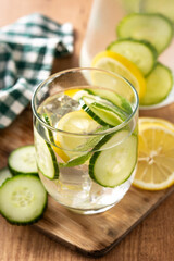 Sassy water or water with cucumber and lemon on wooden table