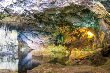 Wide view of cave hall with underground lake and stalactite decoration, Grotte di Nettuno (Nettuno caves), Sardinia, Italy.