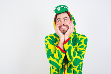 Fototapeta premium Inspired young caucasian man wearing a pajama standing against white wall looking at copyspace having thoughts about future events