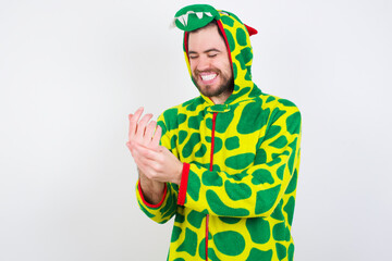 Fototapeta premium young caucasian man wearing a pajama standing against white wall Suffering pain on hands and fingers, arthritis inflammation