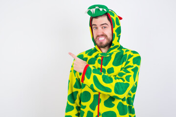 Fototapeta premium young caucasian man wearing a pajama standing against white wall Pointing aside worried and nervous with forefinger, concern and surprise concept.