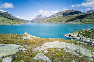Summer mountain scenery in Swiss Alps. Majestic mountains above turquoise lake. Sunny day in nature.