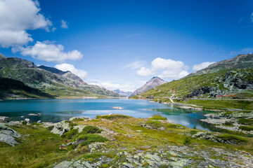 Naklejka na ściany i meble Amazing panoramic view of summer mountain landscape. Mountain lake in Swiss Alps. Sunny day in nature.