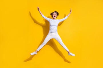 Fototapeta na wymiar Photo of excited lady jump star shape open mouth wear white shirt trousers footwear isolated yellow color background