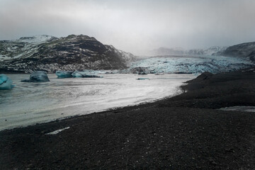 Impressive view of lake with ice floes of melting glacier. Foggy day in Icelandic nature. Cold and icy concept.