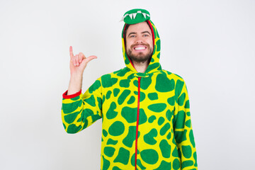 Fototapeta premium young caucasian man wearing a pajama standing against white background showing up number six Liu with fingers gesture in sign Chinese language