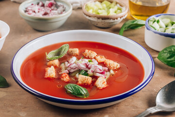Spanish summer cold soup gazpacho with vegetables on beige rustic background.