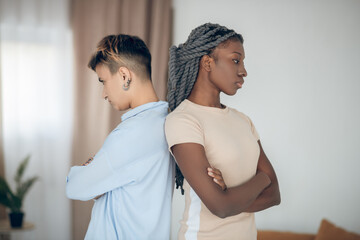 Same sex couple having an argument and standing back to back