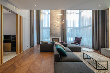 Luxury private house interior. Living room. Huge cozy sofa. Fireplace.