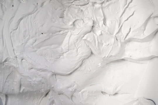 White rough surface with hard texture, putty, foam, background with bulky convex structure under hard light with contrasting shadows. - Powered by Adobe