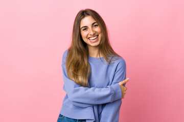 Fototapeta premium Young woman over isolated pink background laughing