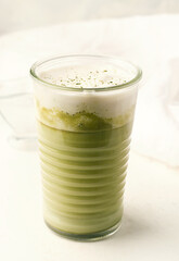 Matcha latte on a white plate close-up.