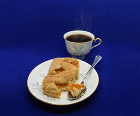 Homemade pie with orange jam and a cup of caffe, sweet food