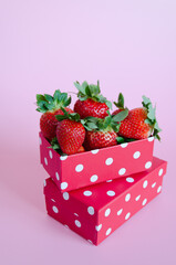 Festive pink background. Fresh strawberries in red gift boxes close up. Love. Valentine's Day. Creative greeting card. Flat lay, top view.