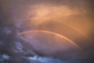 Fototapeta premium two rainbows in the dark sky at sunset