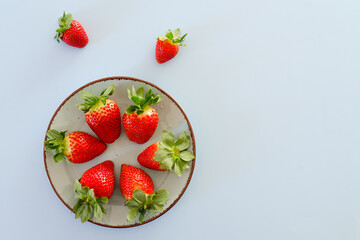 Festive blue background. Red fresh strawberries close up. Valentine's Day. Food backgrounds. Creative greeting card. Flat lay, top view.