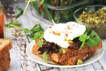 Homemade sandwiches with pesto, green salad and poached eggs