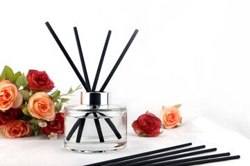 luxury aroma scent reed diffuser glass bottle is on the white table with roses flowers to creat...