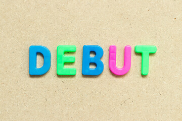 Color alphabet letter with word debut on wood background