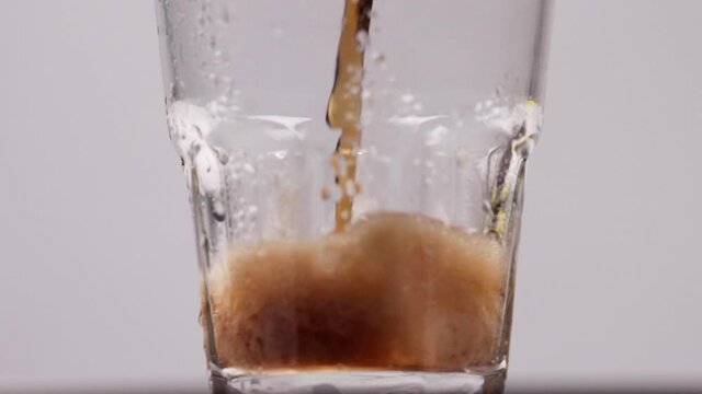 Cola soda pouring into glass of ice with splashes. High quality FullHD footage