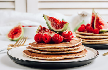 Homemade classic american pancakes with almond, fresh raspberries and figs