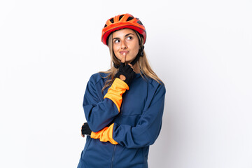 Young hispanic cyclist woman isolated on white background having doubts while looking up