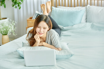 동양인 한국인 아름다운 여성 모델 침대위에서 노트북을 보며 휴식, 쇼핑,...