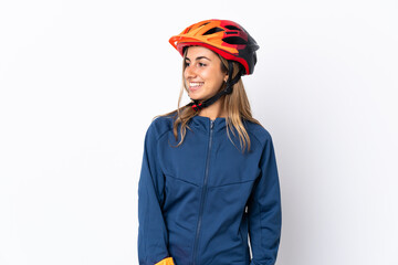 Young hispanic cyclist woman isolated on white background looking to the side and smiling