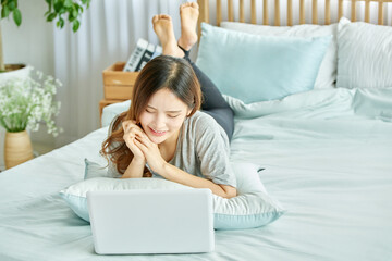 동양인 한국인 아름다운 여성 모델 침대위에서 노트북을 보며 휴식, 쇼핑,...