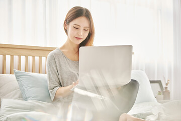 동양인 한국인 아름다운 여성 모델 침대위에서 노트북을 보며 휴식, 쇼핑,...