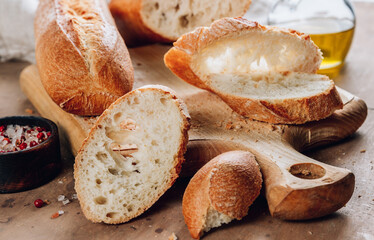 Homemade french two Baguette loafs and cut slice on wooden cutting board