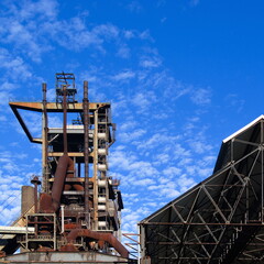 Fototapeta na wymiar Stillgelegte Industrieanlage mit leerstehender Lagerhallt im Ruhrbebiet in Deutschland vor blauem Himmel im Sommer
