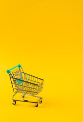 Shopping cart trolley on yellow  background.