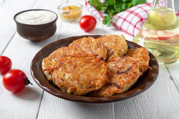 Potato pancakes on a plate on a white wooden background. Vegetarian menu
