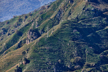 high voltage pylons and cables along the ridge of the mountains in difficult access areas