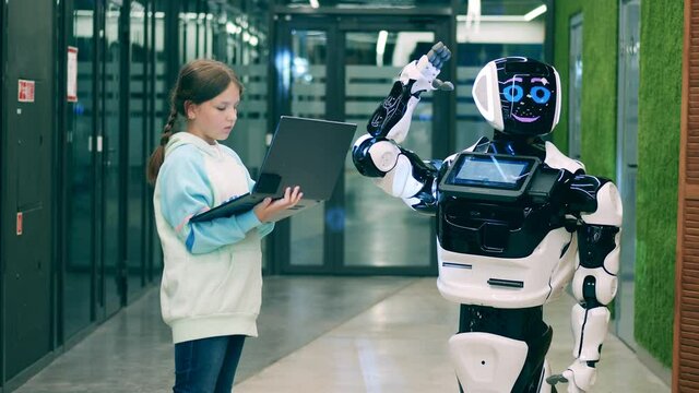 A girl is managing a droid via her laptop