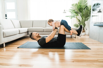 Nice father training with his baby at home