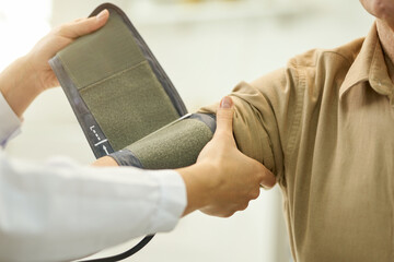 Doctor preparing patient to have blood pressure measured with manometer