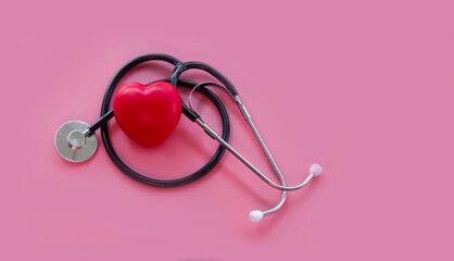 Stethoscope and red hearts on a pink background, Health care concept.