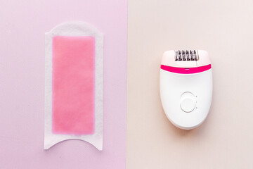 Obraz premium Epilator with pink wax strips. Epilation concept. Top view, flat lay